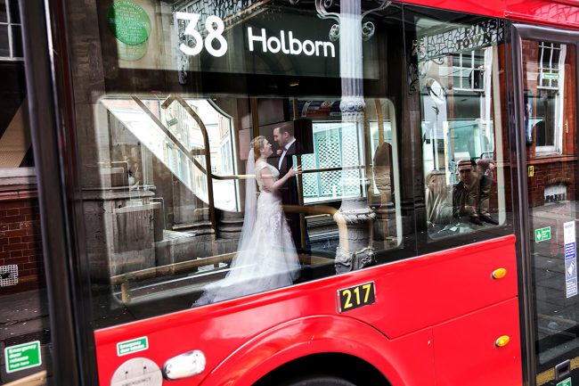 Old-Finsbury-Town-Hall-wedding-1 the bride & groom outside Old Finsbury Town Hall reflected in a bus window