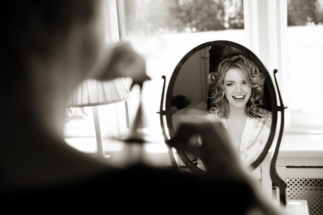 Horsted-Place-wedding-2 bride laughing as she gets ready at Horsted Place