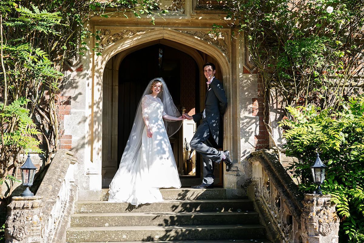 a bride & groom at the entrance to Horsted Place