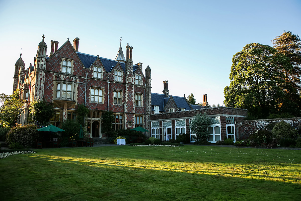 the back exterior of Horsted Place in the evening