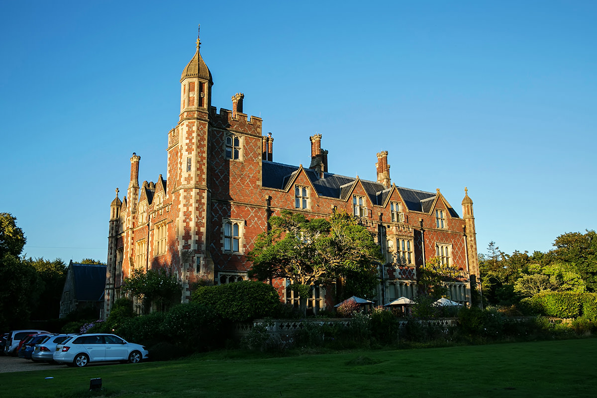 the front exterior of Horsted Place in the evening light