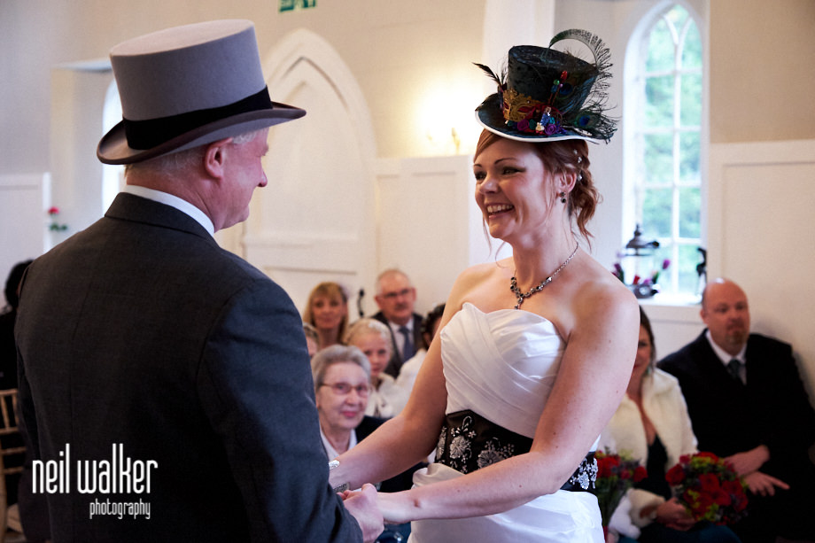 the bride and groom holding hands during the ceremony