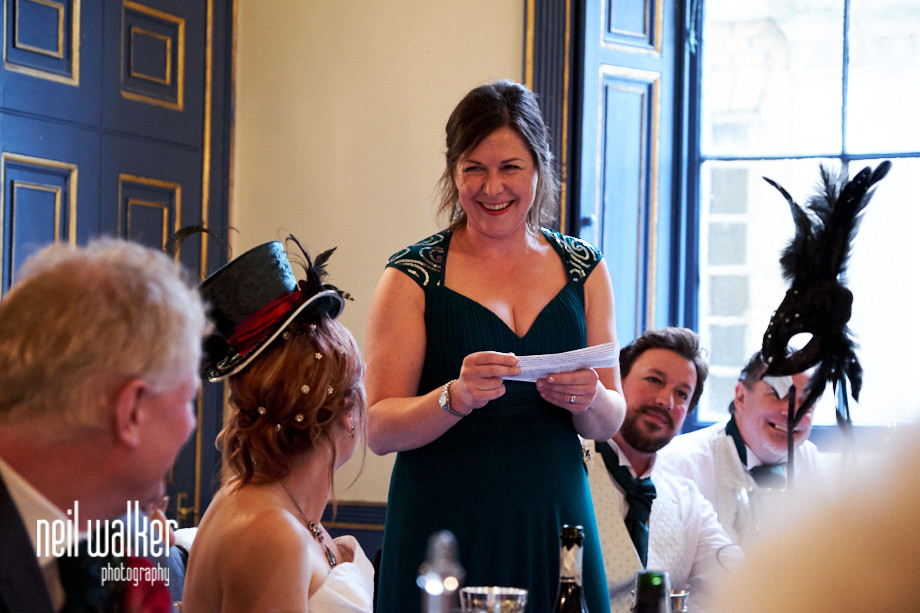the chief bridesmaid smiles at the bride during her speech