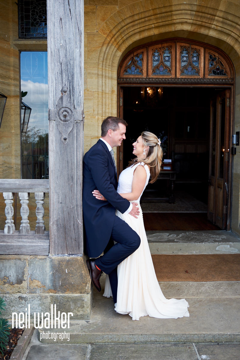the bride and groom by the entrance to Cowdray House