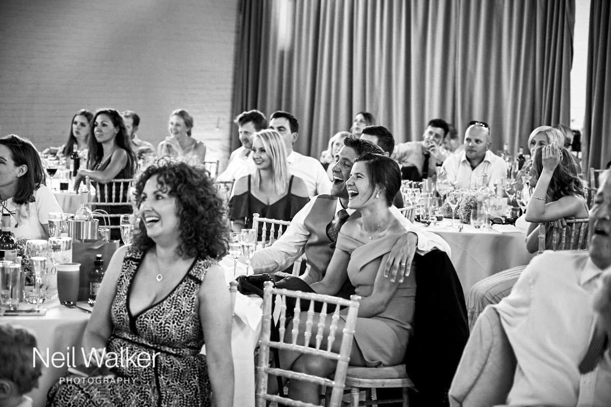 guests laughing at the best man's speech