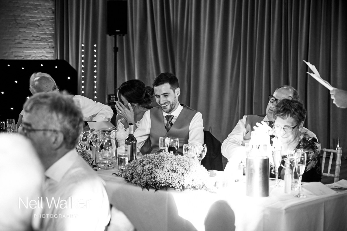 the groom laughing at the best man's speech