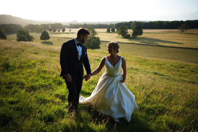 Cissbury-Barns-Wedding-Photographer-0127 A bride and groom walking across the South Downs, photographed by Cissbury Barns wedding photographer Neil Walker.
