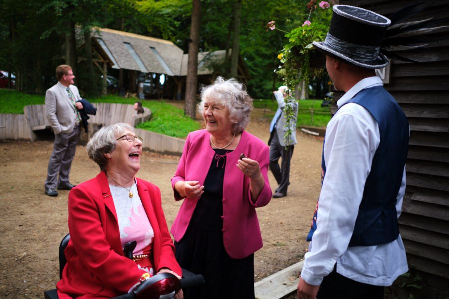 Guests laughing at a wedding at Wilderness Wood in East Sussex.