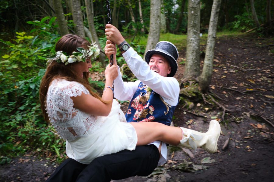 The bride and groom at their wedding at Wilderness Wood sitting on a zip wire.