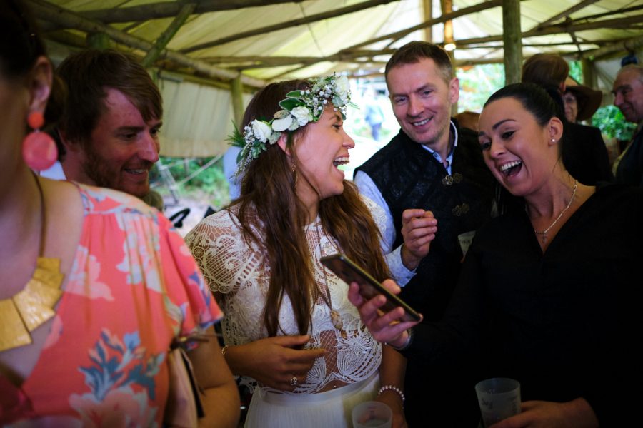 The bride at her wedding at Wilderness Wood laughing with guests.